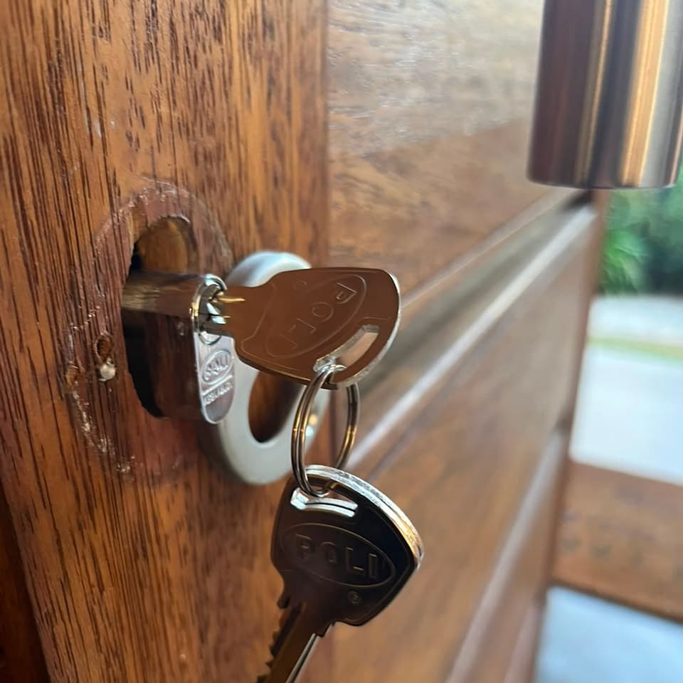 Cilindro nuevo con sus llaves instalado en una puerta de madera