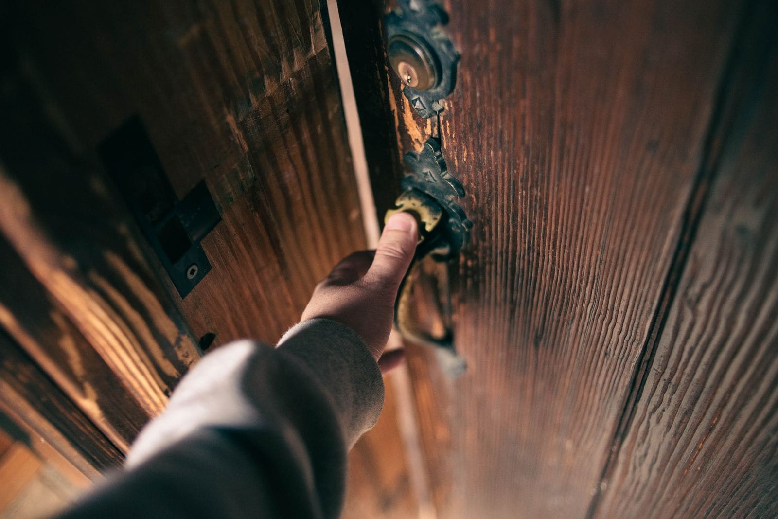 Persona abriendo la puerta de una vivienda con luz cálida de noche